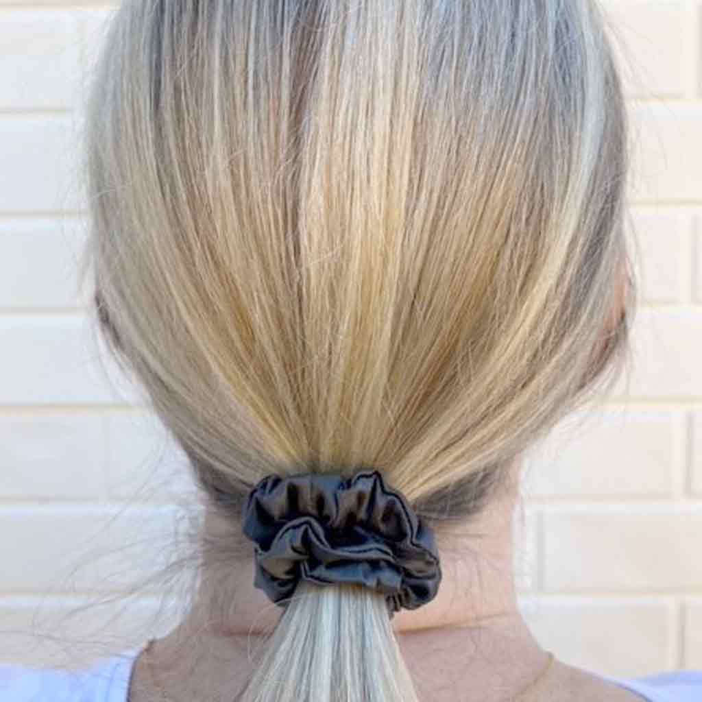 Woman wearing a grey silk scrunchie in her hair