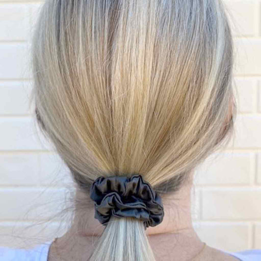 Woman wearing a grey silk scrunchie in her hair