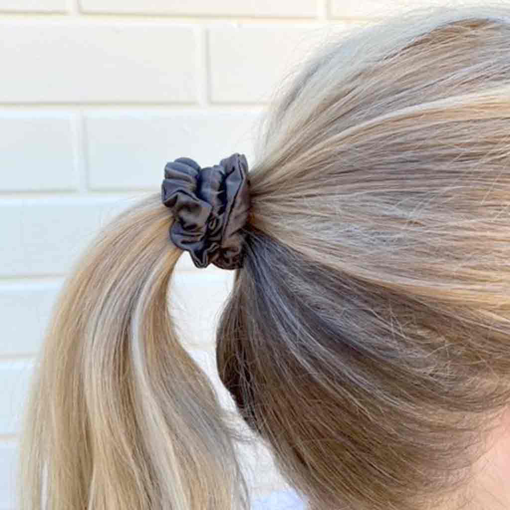Woman wearing a grey silk scrunchie in her hair