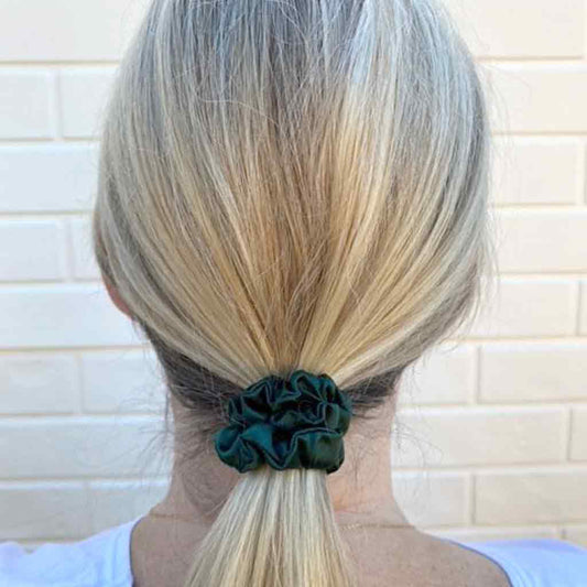 Woman wearing an emerald green silk scrunchie in her hair
