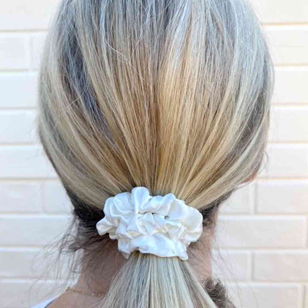 Woman wearing an ivory white silk scrunchie in her hair