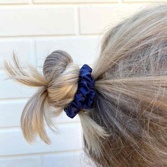 Woman wearing a navy blue silk scrunchie in her hair