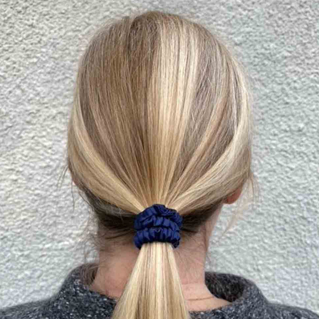 Woman wearing a navy blue silk scrunchie in her hair