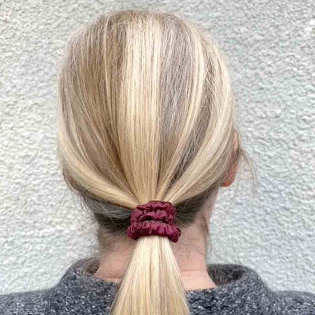 Woman wearing a plum wine silk scrunchie in her hair