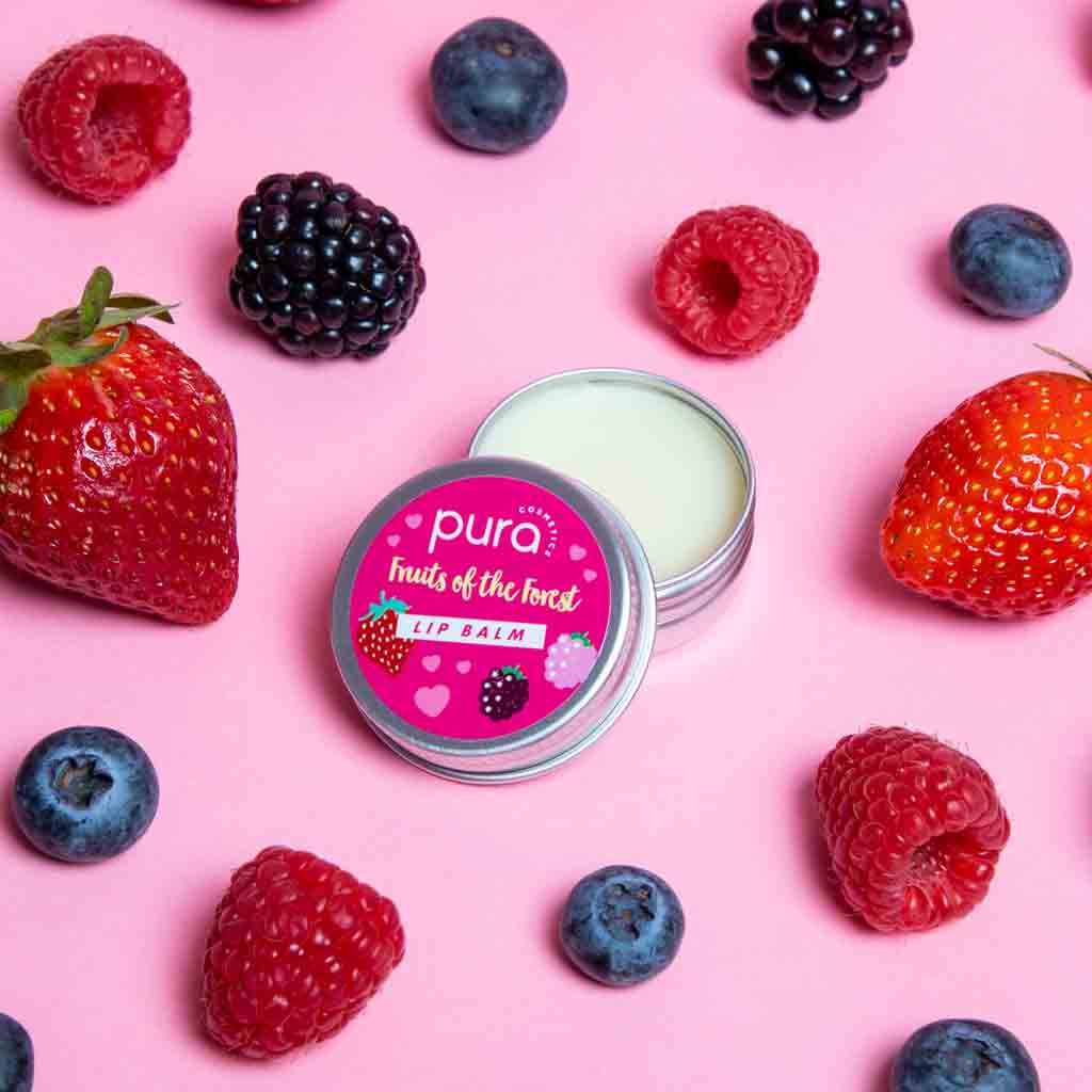A jar of pura cosmetics forest fruits lip balm surrounded by berries