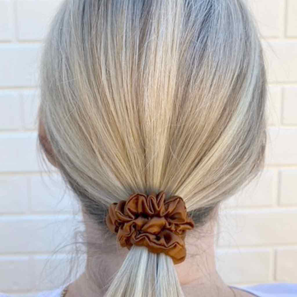 Woman wearing a copper silk scrunchie in her hair