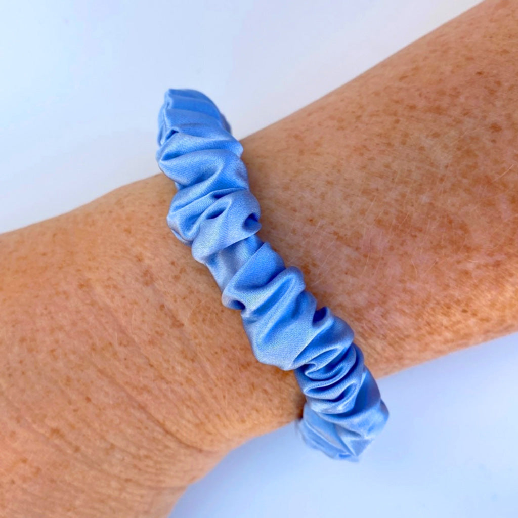 Sky blue silk scrunchie on a woman's wrist