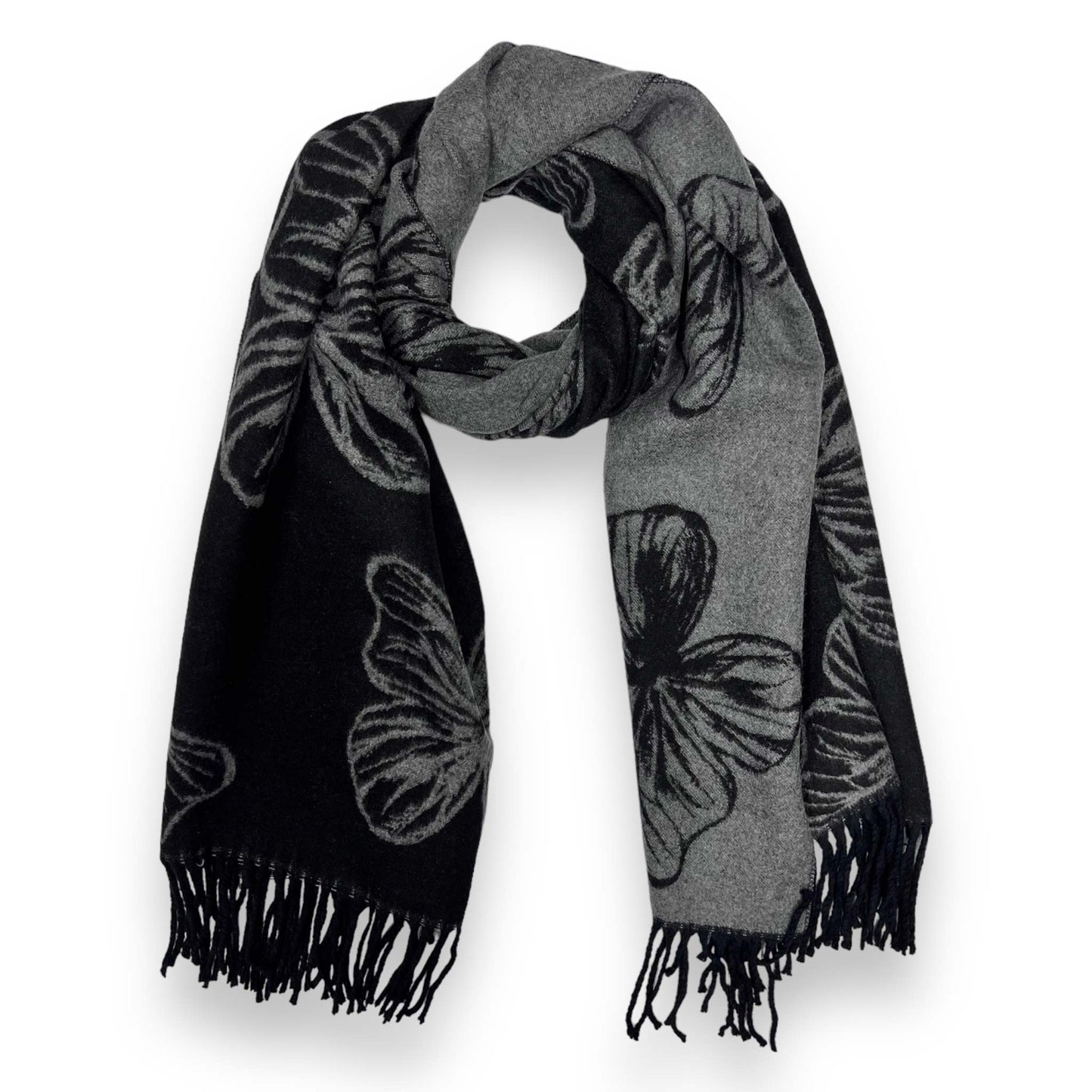 Close-up of a reversible 30% cashmere blend scarf featuring a large charcoal grey and black butterfly print with a classic tassel fringe, draped to show the dual-sided monochrome design.