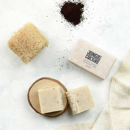 Jungle Culture coffee scrub exfoliant soap bar with ground coffee beans and a natural loofah on a bright textured background