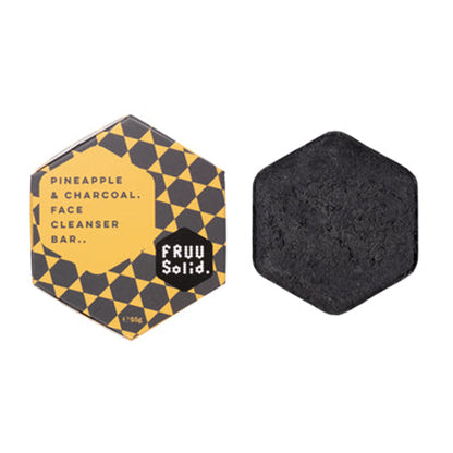 Fruu Pineapple and Charcoal Face Cleanser Bar 55g showing the solid black hexagonal bar next to its yellow and black checkered gift box. 