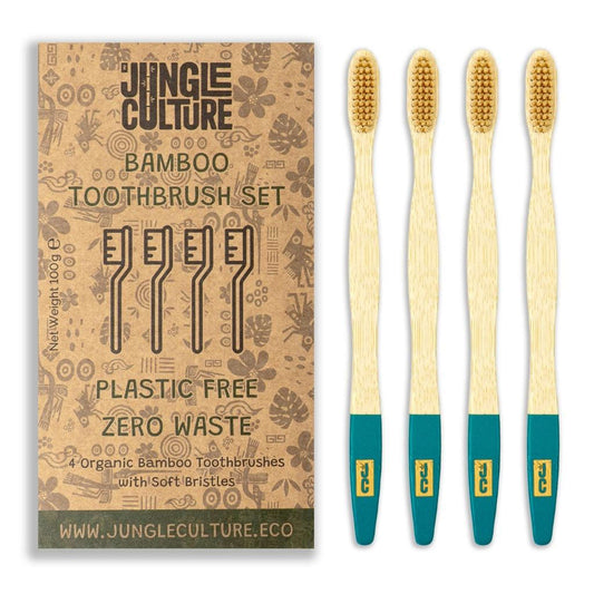 Four Jungle Culture organic bamboo toothbrushes with teal handles and soft bristles next to plastic free zero waste packaging