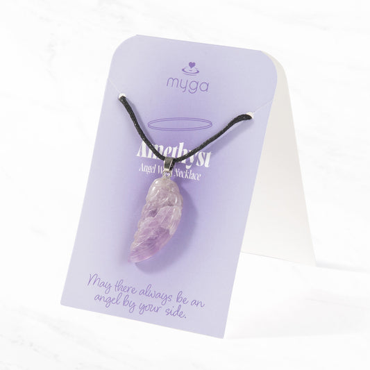 A hand-carved purple Amethyst crystal angel wing pendant on an adjustable black cord, displayed on a soft lilac gift card that reads "May there always be an angel by your side" from the Mybolife Brighton studio.