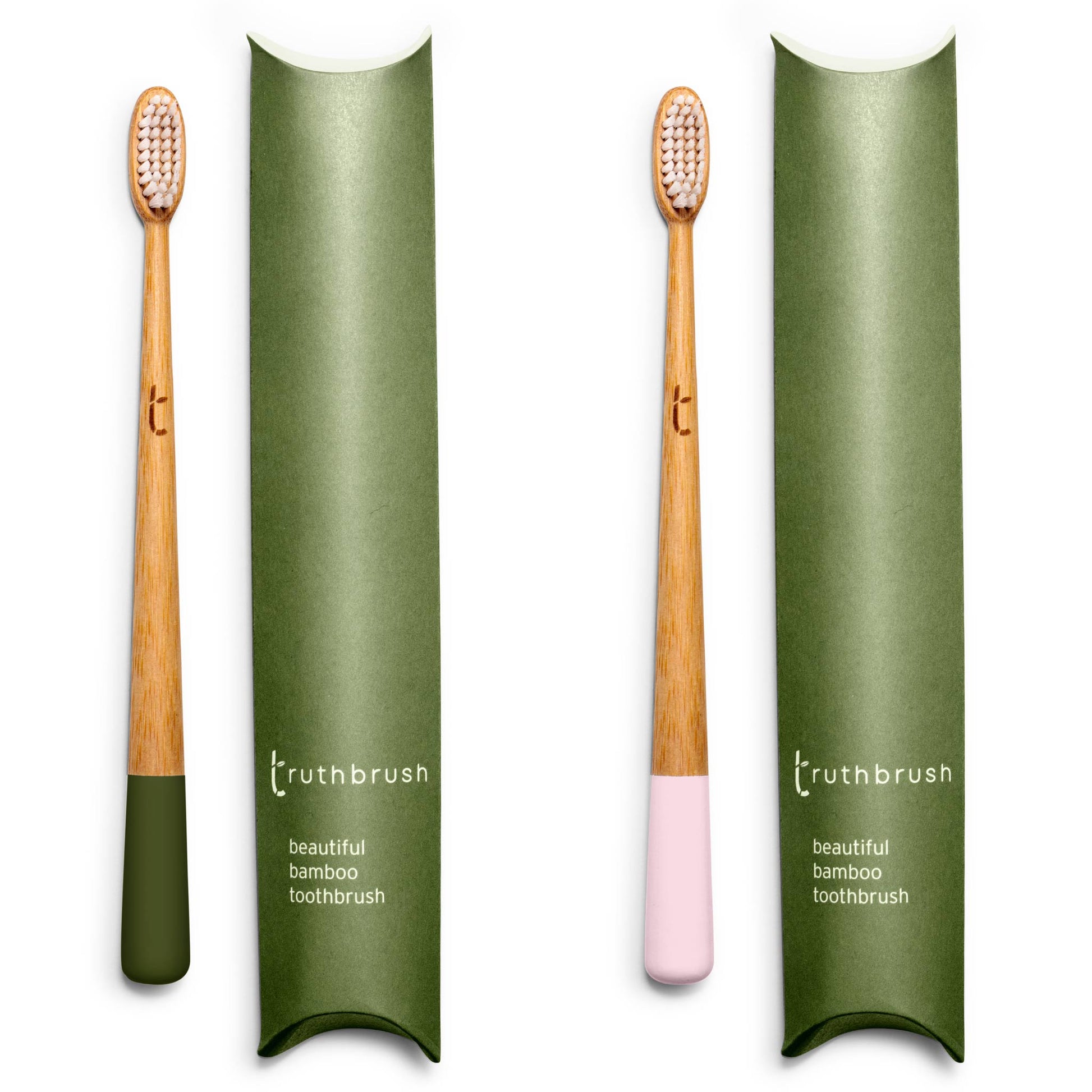 Two Truthbrush bamboo toothbrushes with plant based bristles. One features a deep Moss Green dipped handle and the other a soft Petal Pink dipped handle, both standing next to their sustainable green cardboard pillow pack packaging.